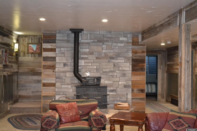 living room featuring a wood stove and wooden walls