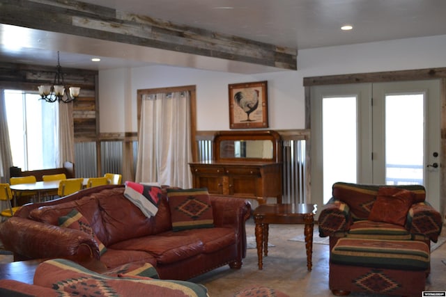 living room with a healthy amount of sunlight, a notable chandelier, and beam ceiling