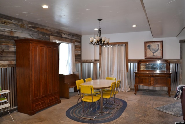 dining room featuring wood walls and an inviting chandelier