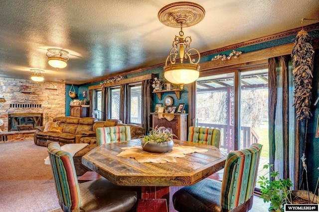 carpeted dining space with a fireplace and a textured ceiling