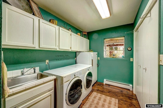 washroom featuring cabinets, sink, independent washer and dryer, baseboard heating, and dark hardwood / wood-style flooring