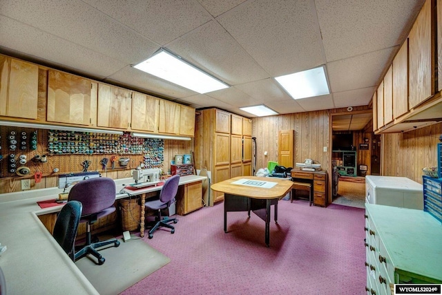 office featuring carpet floors, a drop ceiling, and wood walls