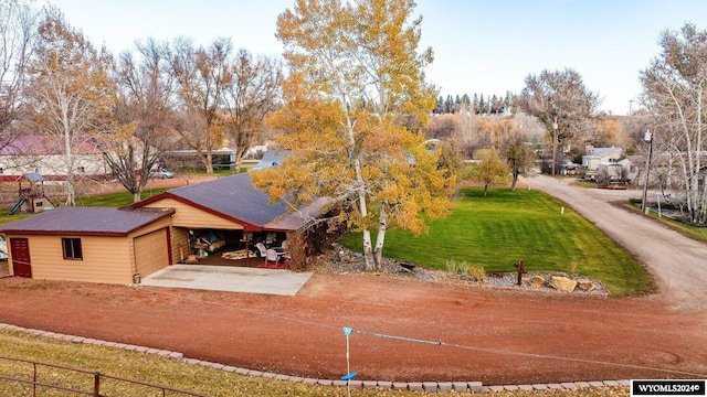 view of front of property featuring a carport, a garage, and a front yard