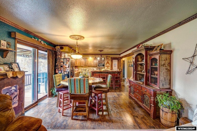 dining space featuring crown molding, dark hardwood / wood-style floors, and a textured ceiling