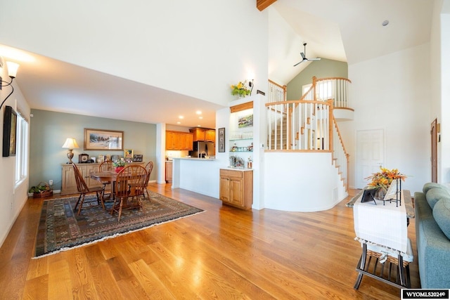 dining room featuring ceiling fan, high vaulted ceiling, and light hardwood / wood-style floors