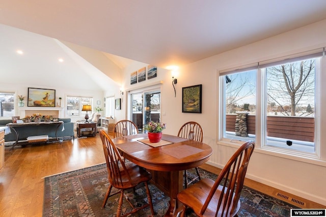 dining area with hardwood / wood-style floors and lofted ceiling