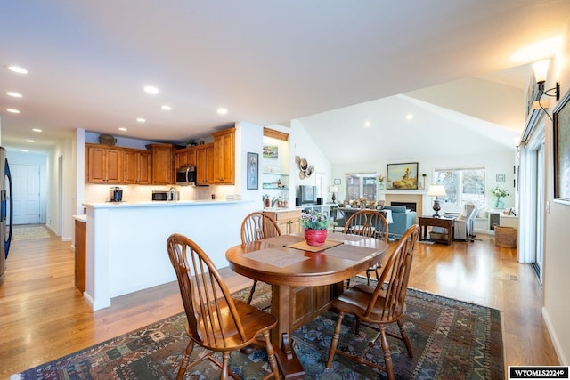 dining area featuring light hardwood / wood-style floors and lofted ceiling