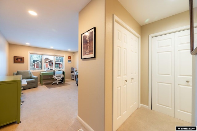 corridor featuring light colored carpet