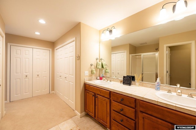 bathroom with tile patterned flooring, vanity, and an enclosed shower