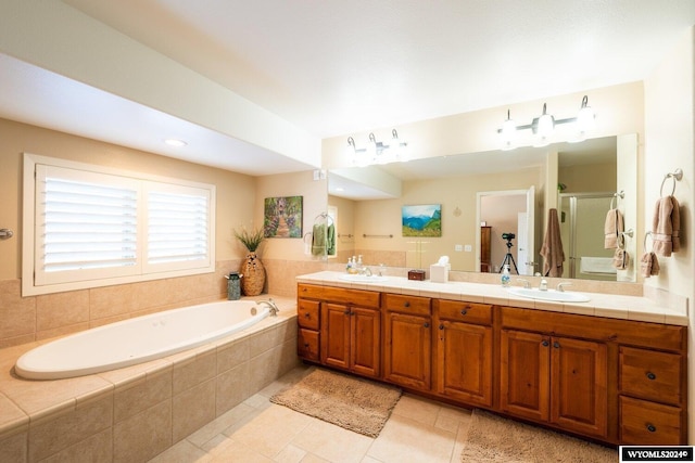 bathroom featuring vanity, tiled bath, and tile patterned floors