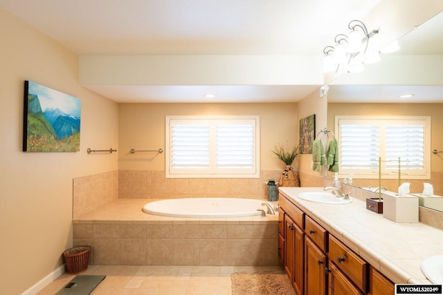 bathroom featuring tile patterned flooring, vanity, a wealth of natural light, and tiled bath