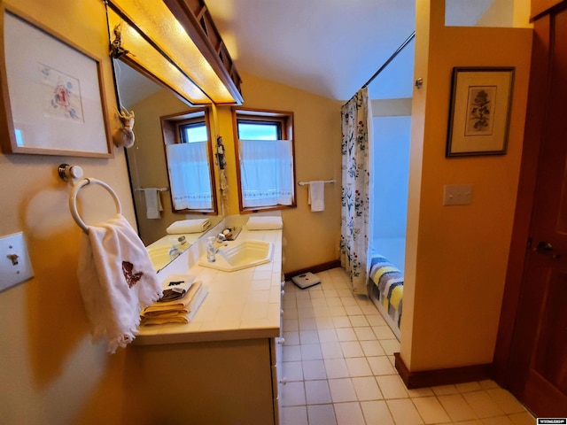 bathroom with shower / bath combo, vanity, vaulted ceiling, and tile patterned floors