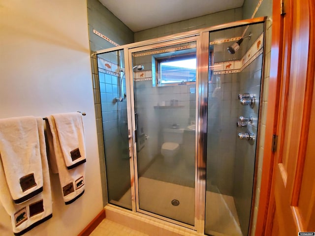 bathroom featuring tile patterned floors, an enclosed shower, and toilet