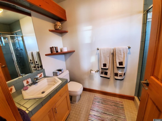 bathroom with vanity, toilet, and a shower with shower door