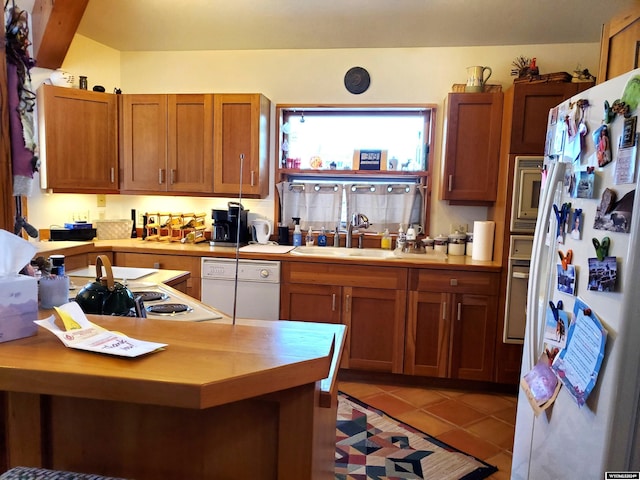 kitchen with light tile patterned flooring, white appliances, and sink