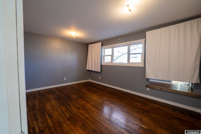 unfurnished room with dark hardwood / wood-style flooring