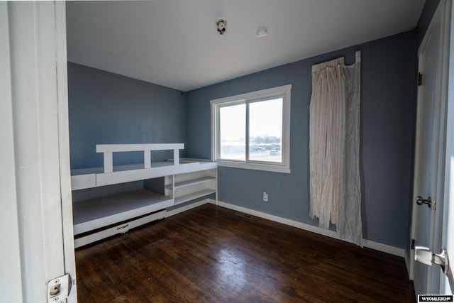 unfurnished bedroom with dark hardwood / wood-style flooring