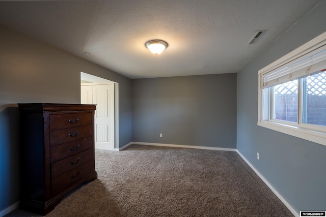 unfurnished bedroom with light carpet and a textured ceiling