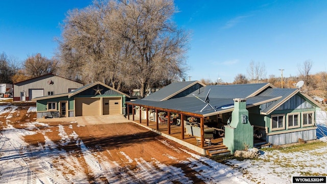 view of front of property featuring an outbuilding, a garage, and covered porch