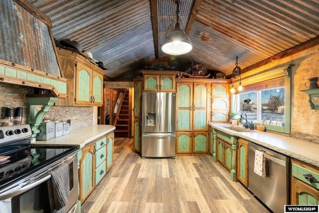 kitchen with sink, hanging light fixtures, light hardwood / wood-style floors, lofted ceiling, and appliances with stainless steel finishes