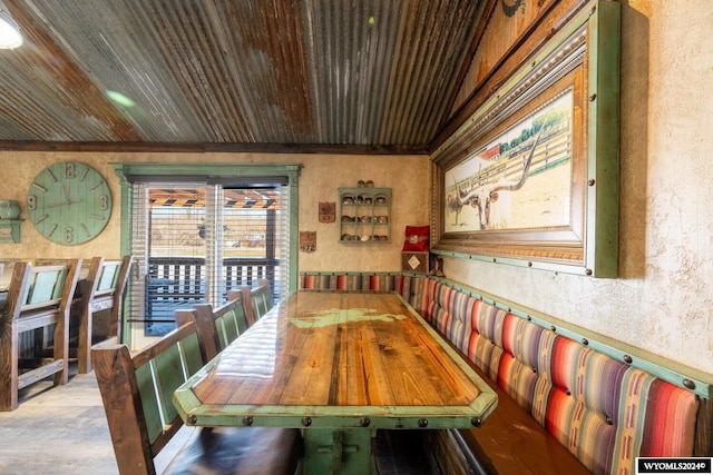 dining area featuring wood ceiling and concrete flooring