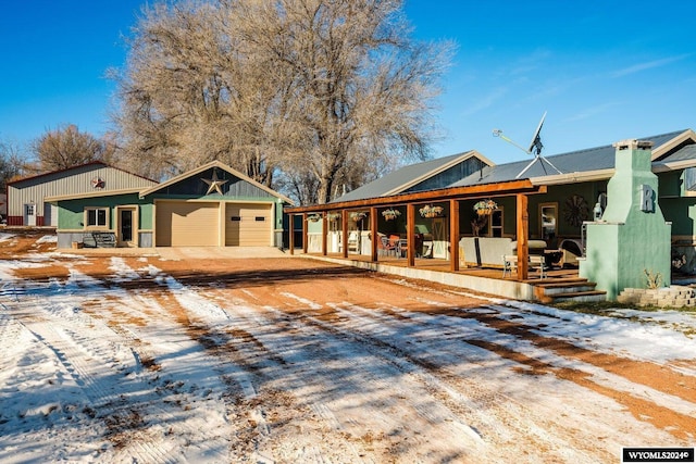 view of front of property featuring a porch, an outdoor structure, and a garage