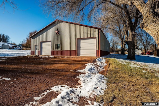 snow covered structure with a garage