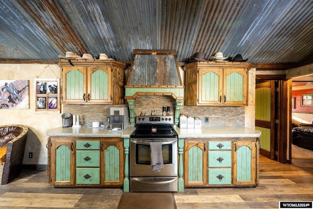 kitchen with backsplash, light hardwood / wood-style flooring, stainless steel range with electric stovetop, and custom exhaust hood