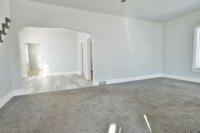 spare room with ceiling fan and light carpet