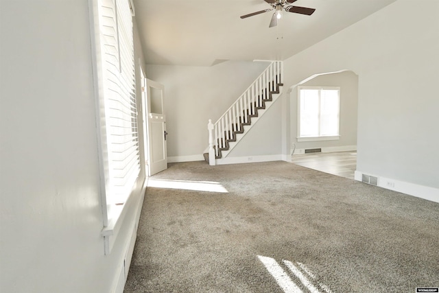 unfurnished living room featuring ceiling fan and carpet floors