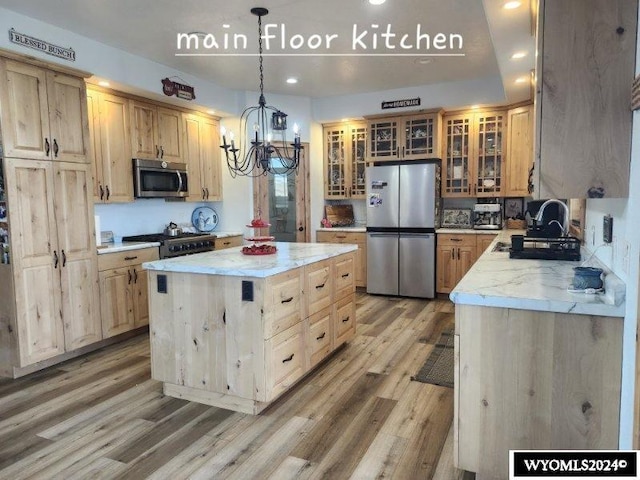 kitchen with a center island, stainless steel appliances, light hardwood / wood-style flooring, a chandelier, and decorative light fixtures