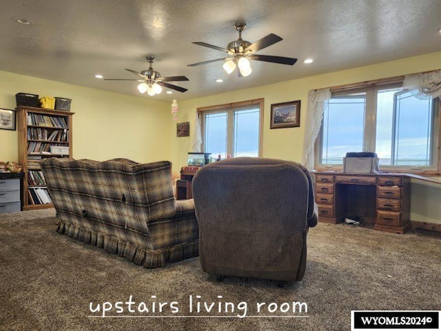 living room with carpet flooring, ceiling fan, and a textured ceiling