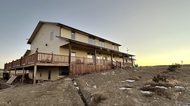 back house at dusk with a wooden deck