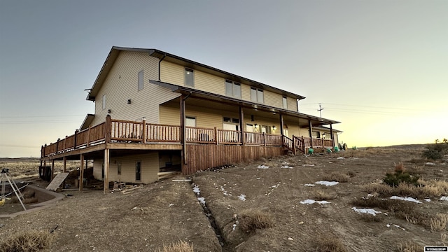 back house at dusk with a deck