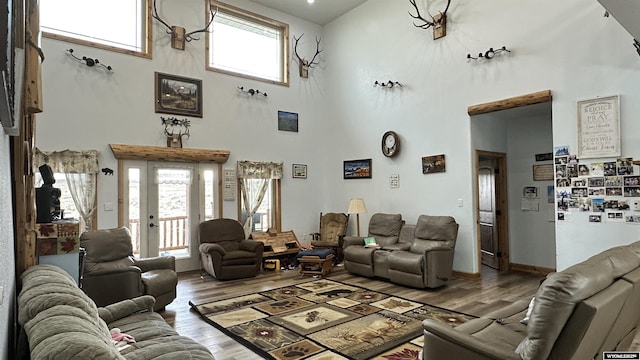 living room with wood-type flooring and a high ceiling