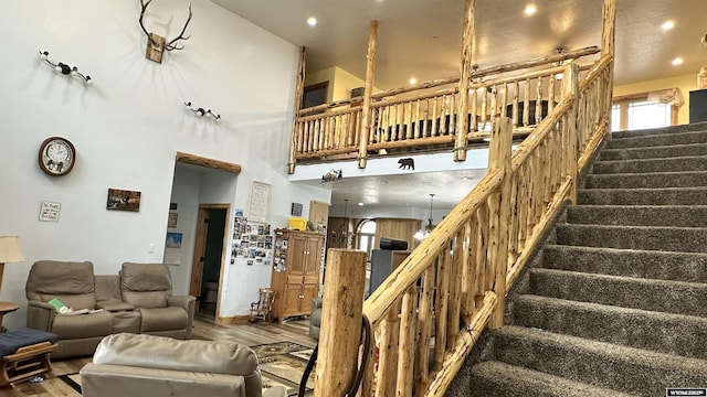 living room with hardwood / wood-style floors and a towering ceiling