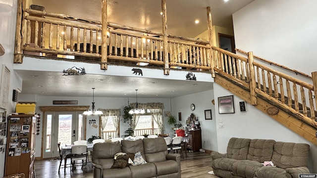 living room with wood-type flooring, french doors, and a notable chandelier