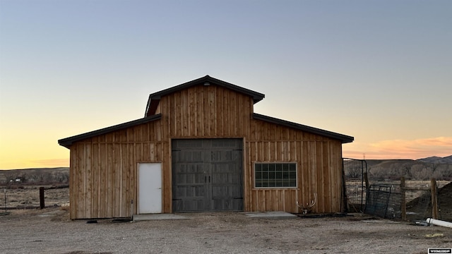 outdoor structure at dusk featuring a mountain view and a garage