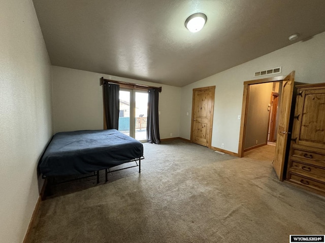 bedroom with light colored carpet, a textured ceiling, access to outside, and vaulted ceiling