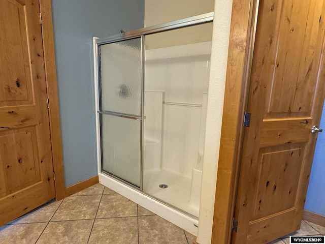 bathroom with tile patterned floors and an enclosed shower