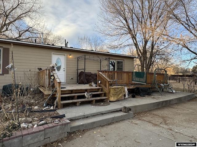 rear view of house featuring a wooden deck