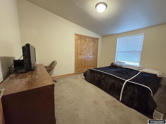 bedroom with light carpet and lofted ceiling