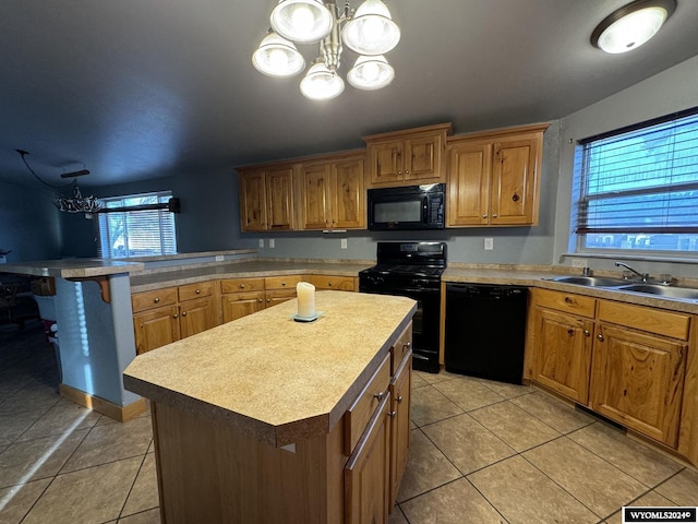 kitchen with a center island, a wealth of natural light, a notable chandelier, and black appliances