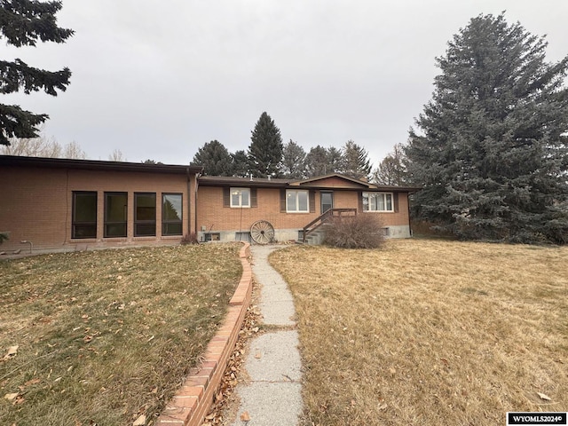 single story home featuring brick siding and a front lawn