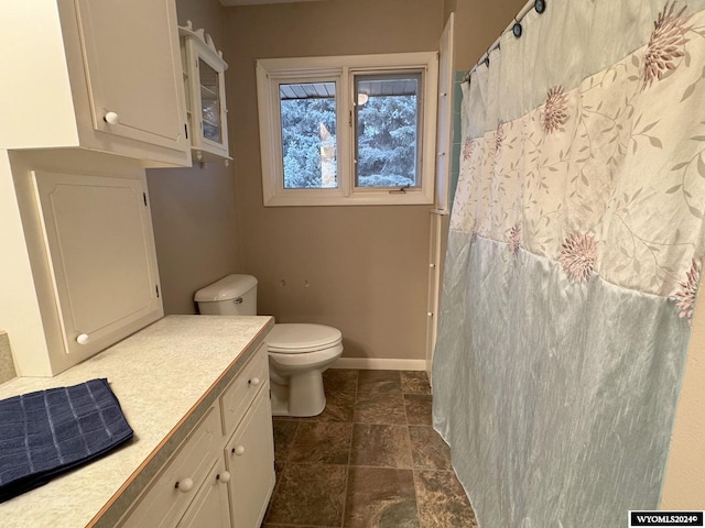 full bath with curtained shower, baseboards, vanity, and toilet