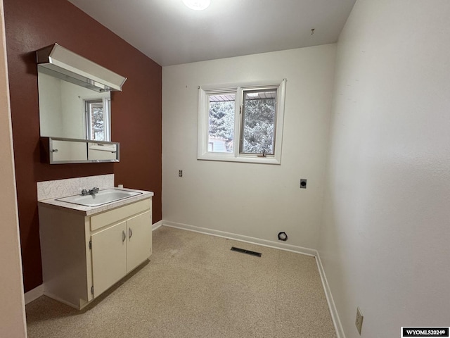 clothes washing area with cabinet space, visible vents, hookup for an electric dryer, a sink, and plenty of natural light