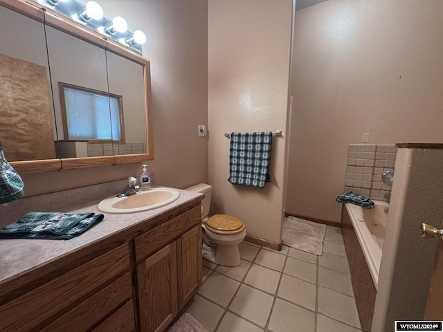 full bathroom featuring a washtub, toilet, vanity, baseboards, and tile patterned floors