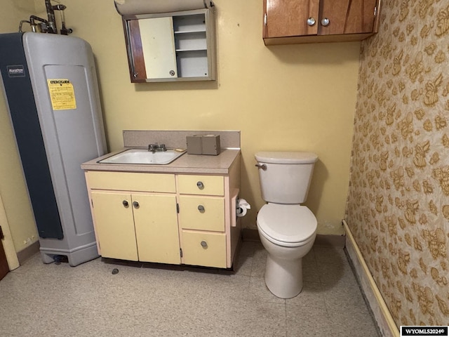 bathroom featuring vanity, toilet, and baseboards