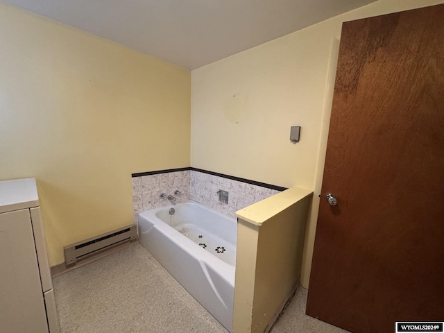 bathroom with washer / dryer, a baseboard radiator, and a bath