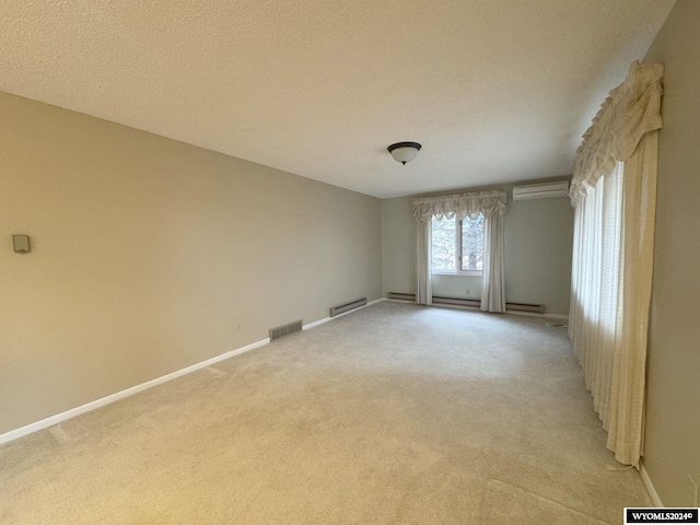 empty room with baseboards, baseboard heating, visible vents, and light colored carpet